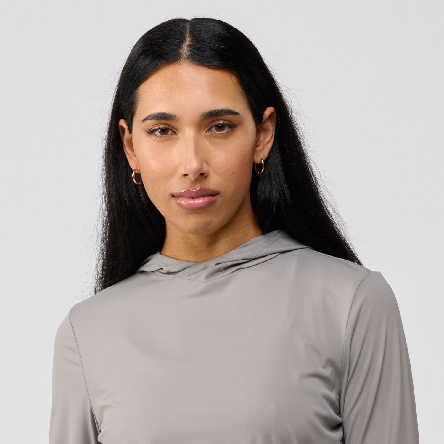 Woman wearing a gray long-sleeve top against a light gray background