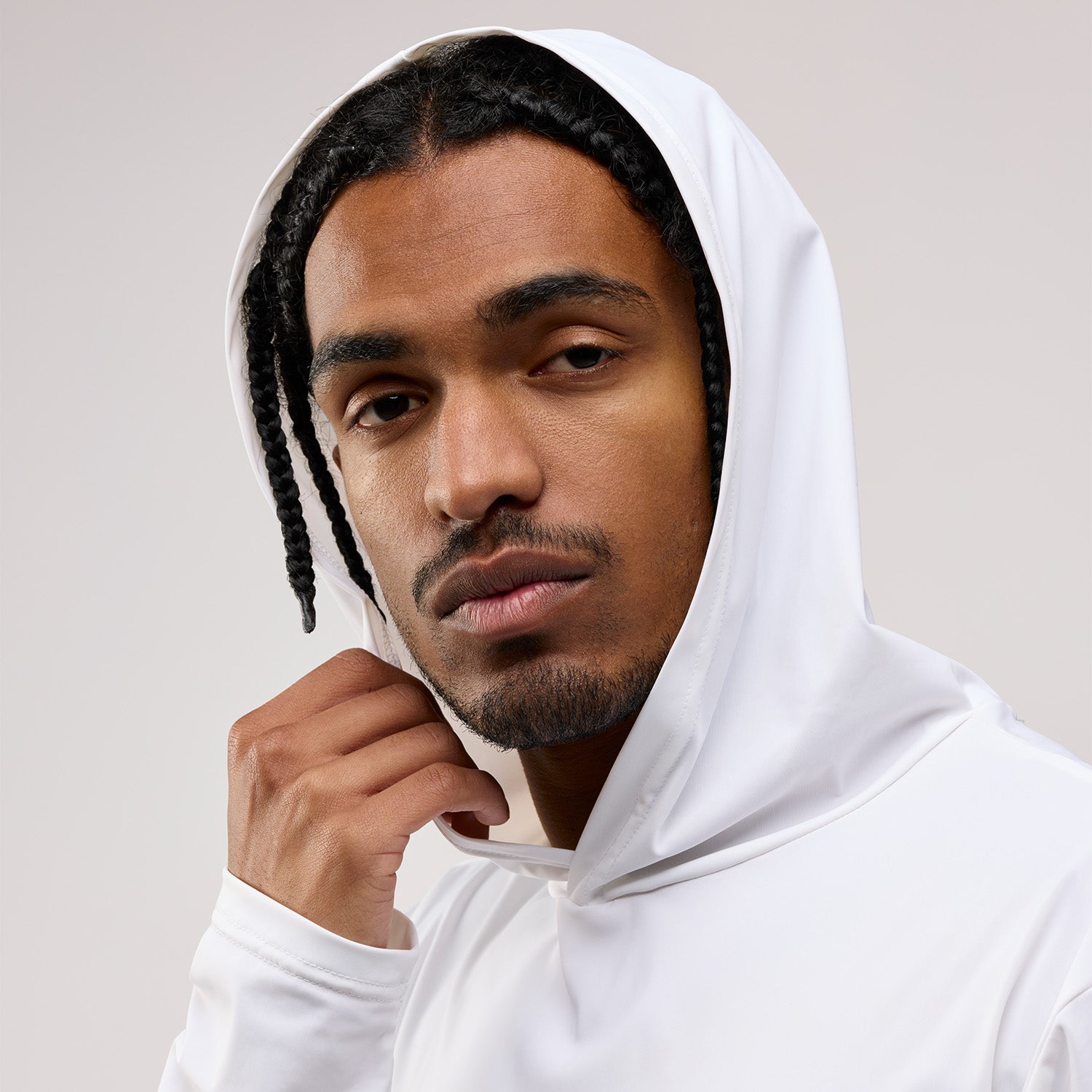 Man wearing a white hoodie against a plain background